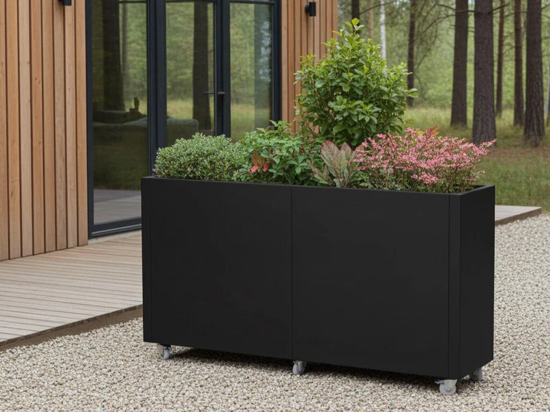 Plantekasse på hjul i svart stål med busker og blomster