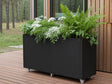 Plantekasse i svart stål på hjul med frodig beplantning