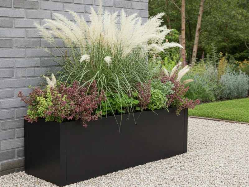 Plantekasse i svart stål med prydgress i grusbed