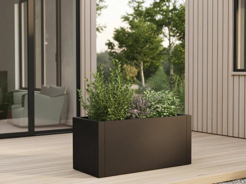 Plantekasse i svart stål med busker og stauder på terrasse