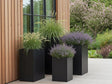 Høye plantekrukker i svart stål med prydgress