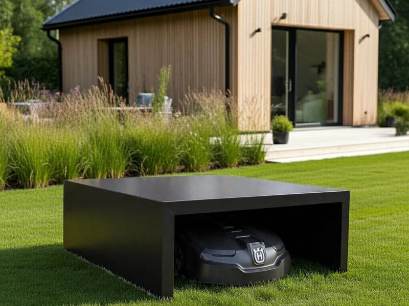 Moderne robotgressklipper garasje i svart stål ved terrasse