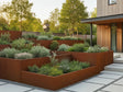 Støttemur i cortenstål rundt terrasserte plantebed