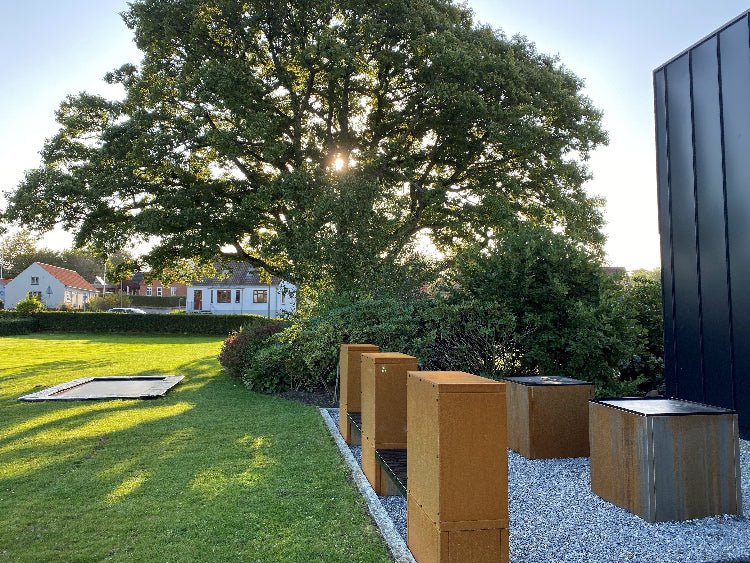 Vedlagring i cortenstål med sittebenk på moderne terrasse