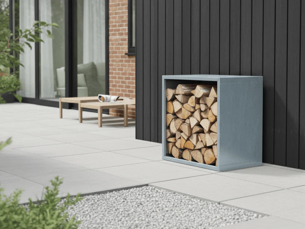 Vedoppbevaring i grålakkert stål fylt med ved på moderne terrasse