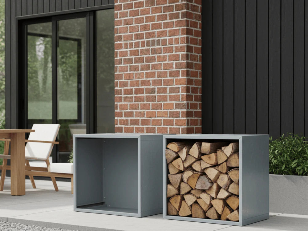 Modulbasert vedstativ i grålakkert stål, tom og fylt med ved, ved husfasade